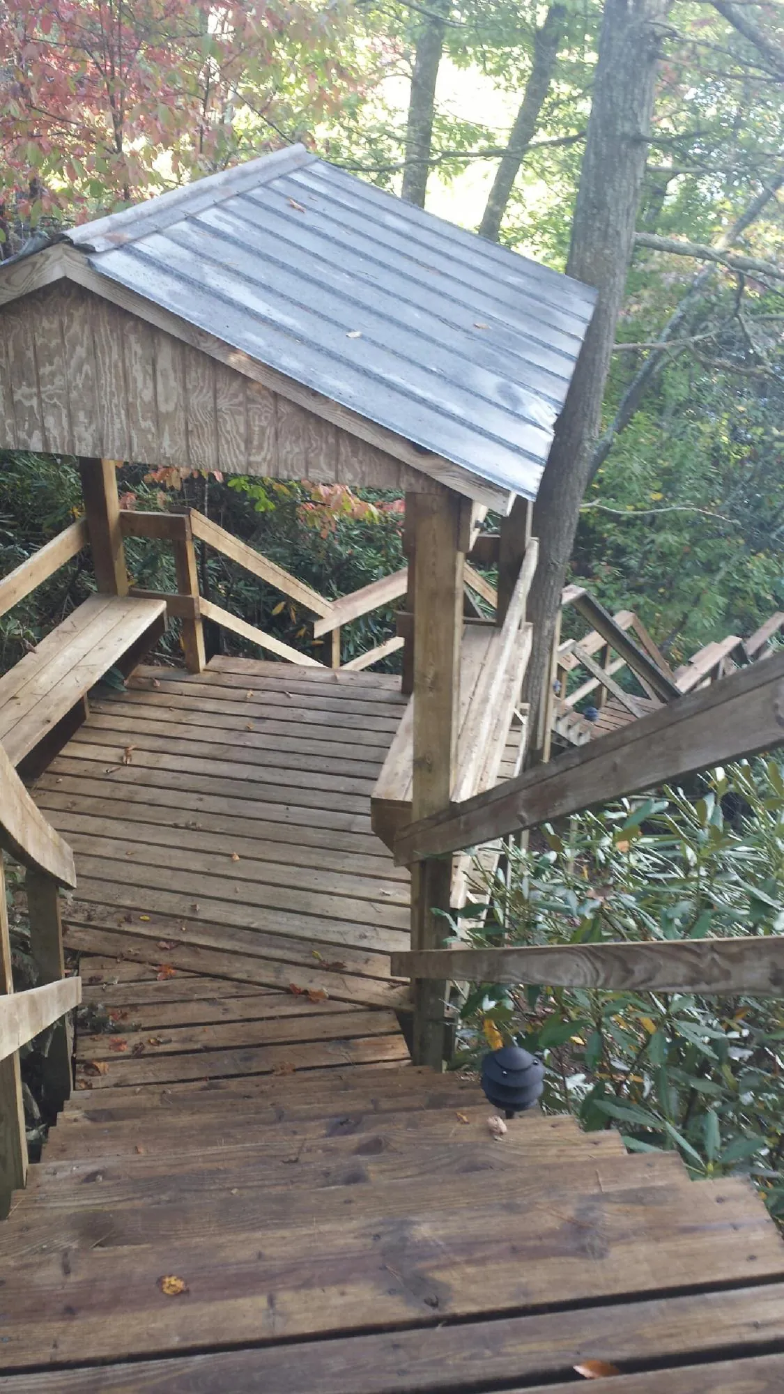 Metal roofed shelter over wooden steps on a wooded walkway — Skylight Repair & Installation work by our crew in Fulton