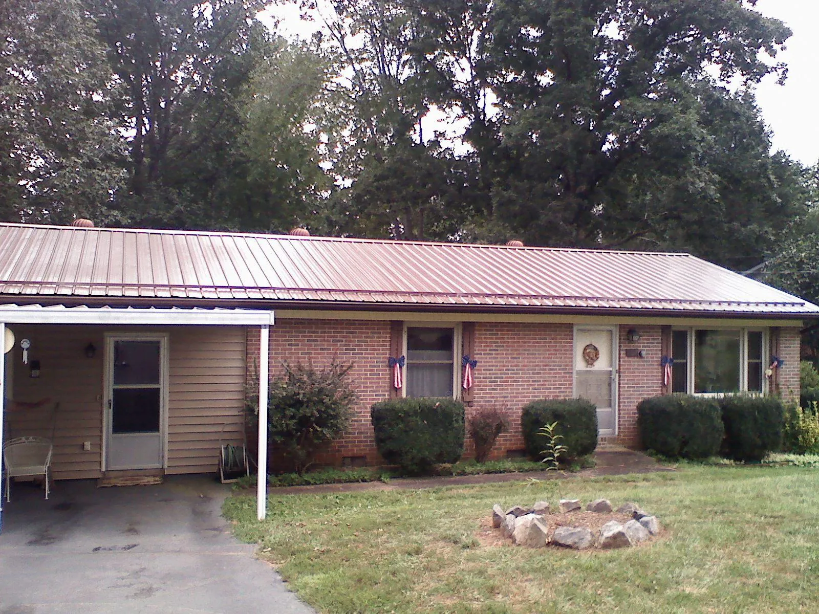 Bronze metal roof and carport on a brick ranch home — Roof Repair work by our crew in Fulton